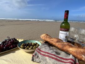 A beach setting with wine, bread, olives, grapes and glasses at Kippy Cottage in Truro
