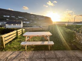 An outdoor area with a table and bench overlooking the sea at Kippy Cottage in Truro