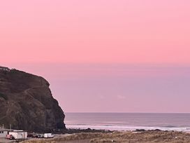 A coastal scene with a cliff and sea at Kippy Cottage in Truro