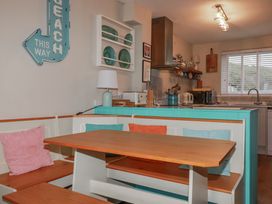 A dining area with a table and benches at Kippy Cottage in Porthtowan