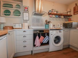 A kitchen with appliances and utensils at Kippy Cottage Porthtowan