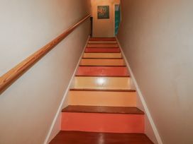 A staircase with wooden stairs and a handrail at Kippy Cottage in Porthtowan