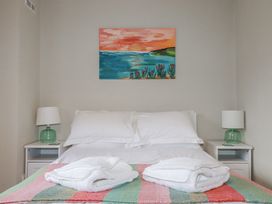 A bedroom with a bed and nightstands at Kippy Cottage Porthtowan