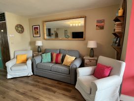 A living room with a sofa and armchairs at Kippy Cottage Porthtowan