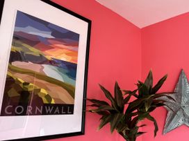 A picture frame with artwork and a plant at Kippy Cottage in Porthtowan