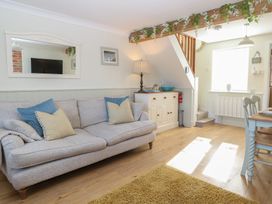 A living room with a sofa and table at Herbies Cottage in Snettisham