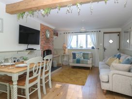A living room with a dining table and chairs at Herbies Cottage in Snettisham