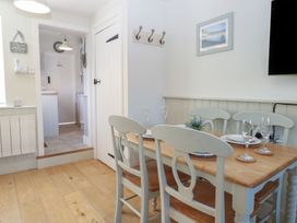 A dining room with a table and chairs at Herbies Cottage in Snettisham