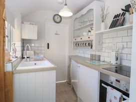 A kitchen with a sink and stove at Herbies Cottage in Snettisham