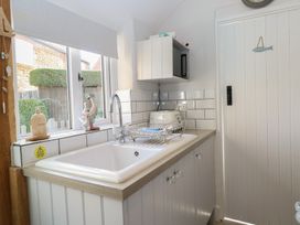 A kitchen with a sink and dish rack at Herbies Cottage in Snettisham