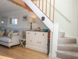 A living room with a sofa and stairs at Herbies Cottage in Snettisham