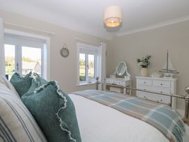A bedroom with a bed and dresser at Herbies Cottage in Snettisham