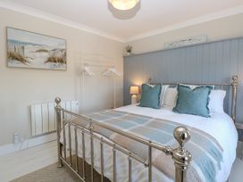 A bedroom with a bed and wall art at Herbies Cottage in Snettisham
