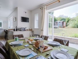 A dining room with a table set for a meal at St Helena in Charmouth
