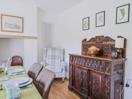 A dining room with a sideboard and dining table at St Helena in Charmouth