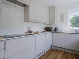 A kitchen with a stove and microwave at St Helena in Charmouth