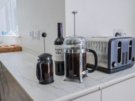 A kitchen with a french press and a wine bottle at St Helena in Charmouth