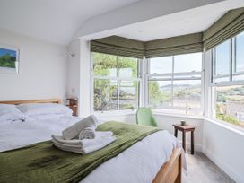 A bedroom with a bed and window view at St Helena in Charmouth
