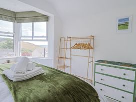 A bedroom with a bed and a clothing rack at St Helena in Charmouth