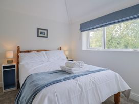 A bedroom with a bed and bedside tables at St Helena in Charmouth
