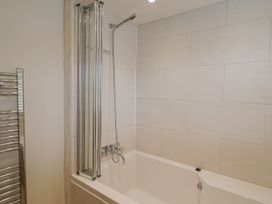 A bathroom with a bathtub and shower at St Helena in Charmouth