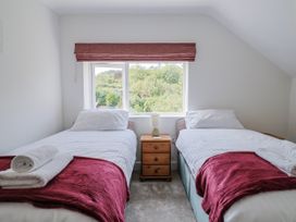 A bedroom with two single beds and a window at St Helena in Charmouth