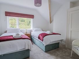 A bedroom with two beds and a window at St Helena in Charmouth
