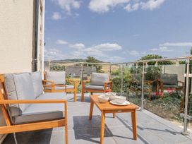 A balcony with seating and a table at St Helena in Charmouth