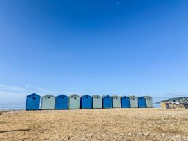 Beach huts on sandy shore at St Helena in Charmouth