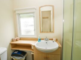 A bathroom with a sink a mirror a window and a shower at 4 Old Orchard in Brockton near Much Wenlock