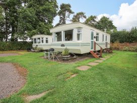 Two white mobile homes with steps on a grassy area with trees at 5 Old Orchard in Brockton near Much Wenlock