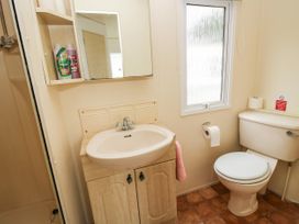 A bathroom with a sink cabinet mirror window toilet and shower at 5 Old Orchard in Brockton near Much Wenlock