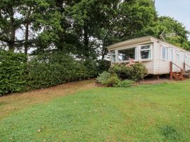 A mobile home with stairs surrounded by grass and trees at 7 Old Orchard in Brockton near Much Wenlock