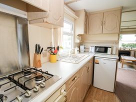 A kitchen with a gas stove sink utensils microwave toaster and fridge at 7 Old Orchard in Brockton near Much Wenlock