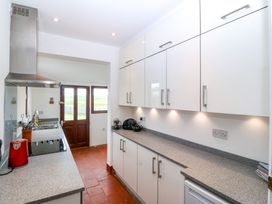 A kitchen with a stove and kettle at Faraway in Rhosneigr