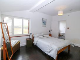 A bedroom with a bed and a mirror at Faraway in Rhosneigr