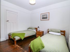 A bedroom with two beds and a nightstand at Faraway in Rhosneigr