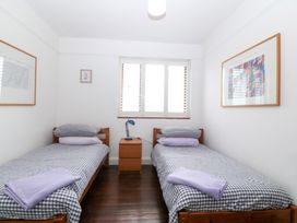 A bedroom with two single beds and a bedside table at Faraway in Rhosneigr