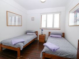 A bedroom with twin beds and a nightstand at Faraway in Rhosneigr