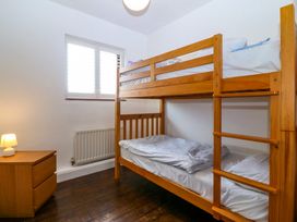 A bedroom with a bunk bed and a bedside table at Faraway in Rhosneigr