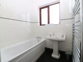 A bathroom with a bathtub and sink at Faraway in Rhosneigr