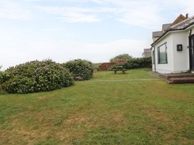 A house with bushes and a table in the garden at Faraway Rhosneigr