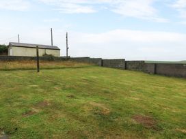An outdoor area with grass and a building at Faraway in Rhosneigr