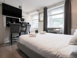 A bedroom with a bed and kitchen area at Bowness Central in Bowness-On-Windermere