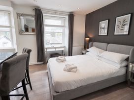A bedroom with a bed and a table at Bowness Central in Bowness-On-Windermere