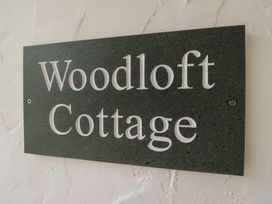 A sign displaying Woodloft Cottage at Woodloft Cottage Elterwater near Chapel Stile