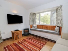 A living room with a tv and a bench at Woodloft Cottage Elterwater near Chapel Stile