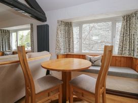 A dining area with a table and chairs at Woodloft Cottage Elterwater near Chapel Stile