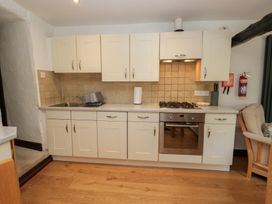 A kitchen with cabinets, sink, and stove at Woodloft Cottage Elterwater near Chapel Stile