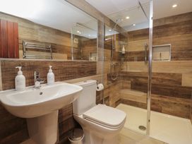 A bathroom featuring a shower, sink, and toilet at Woodloft Cottage Elterwater near Chapel Stile